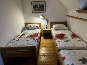 two twin beds in a room with a lamp at Melisa's Holiday Home in Mostec