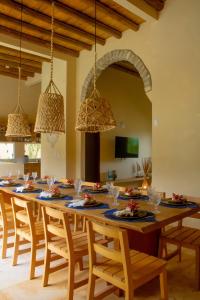 ein Esszimmer mit einem großen Holztisch mit Stühlen in der Unterkunft Villa Bella - São Miguel do Gostoso in Touros