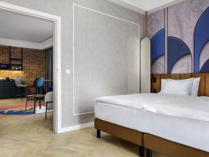 a bedroom with a bed and a living room at Mercure Krakow Fabryczna City in Kraków +162 photos