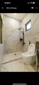 une salle de bain blanche avec toilettes et douche dans l'établissement Nhà lá Miền Tây Việt Nam, 