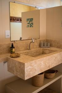 ein Badezimmer mit einem großen Marmorwaschbecken und einem Spiegel in der Unterkunft Villa Bella - São Miguel do Gostoso in Touros