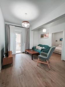 アテネにあるCenter Athens all new and fully equipped 2 bedrooms 82 sqm big sea view apt close to Acropoli with Liftの緑のソファとテーブルのあるリビングルーム