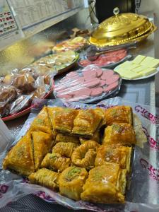 ein Tisch mit verschiedenen Gebäcksorten und Fleisch in der Unterkunft Chorminor 150 m to Old Town Free Dinner LA Coffee in Buxoro