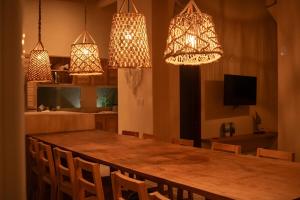 ein Esszimmer mit einem Tisch und Kronleuchtern in der Unterkunft Villa Bella - São Miguel do Gostoso in Touros