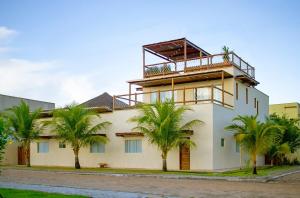 ein Gebäude mit Palmen davor in der Unterkunft Villa Bella - São Miguel do Gostoso in Touros