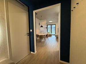 a living room with a table and a dining room at Metropolis- brand new apartment with free parking in Nivy