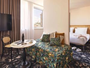 a hotel room with a couch and a table and a bed at Mama Shelter Roma in Rome