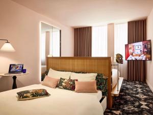 a bedroom with a large white bed with pillows at Mama Shelter Roma in Rome +149 photos
