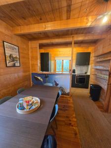 a kitchen and dining room with a table in a cabin at Lodge du Parc des Combes avec Accès Parc inclus selon calendrier ouverture Parc in Le Creusot