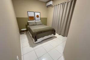 a bedroom with a bed and a white tiled floor at Apê espaçoso e tranquilo pertinho do centro! in Barreiras