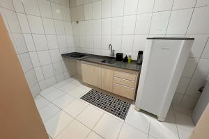 a small kitchen with a sink and a refrigerator at Apê espaçoso e tranquilo pertinho do centro! in Barreiras