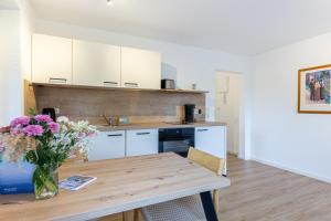 a kitchen with a table and a vase of flowers at Boddenräuber 3 in Ahrenshoop