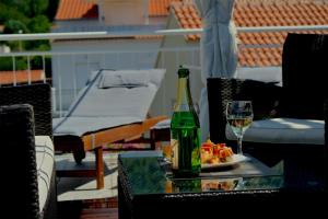 a bottle of wine and a plate of food on a table at Komiza Provita Guesthouse in Komiža