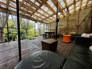 ein großer Raum mit einer Holzterrasse mit einer Couch und einem Tisch in der Unterkunft Ana House of Rest in Cluj-Napoca