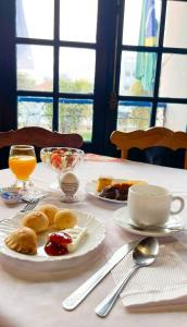 a table with a plate of breakfast food on it at Hotel Lenheiros in São João del Rei