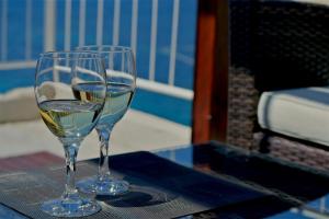 two glasses of wine sitting on a table at Komiza Provita Guesthouse in Komiža