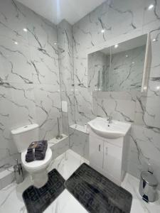 a white bathroom with a toilet and a sink at The Felix Apartments - 1 Bedroom - WIFI - FREE Parking in Flitwick