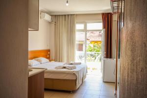 a hotel room with a bed and a window at Özden Pansiyon in Burhaniye