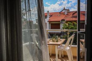 a balcony with a table and chairs and a window at Özden Pansiyon in Burhaniye