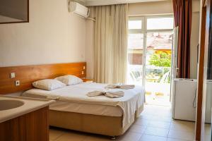 a bedroom with a bed with a sink and a window at Özden Pansiyon in Burhaniye +13 photos