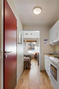a kitchen with a red door leading to a living room at Fjellheim Kurs- og Misjonssenter in Tromsø