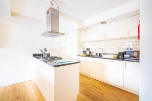 a white kitchen with white cabinets and a counter top at Abbey Church 20 in Fort Augustus