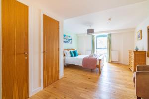 a bedroom with a bed and a wooden door at Abbey Church 20 in Fort Augustus +15 photos