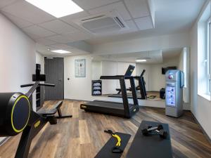 een fitnessruimte met een loopband en fitnessapparatuur in een kamer bij ibis Styles Hamburg Barmbek in Hamburg