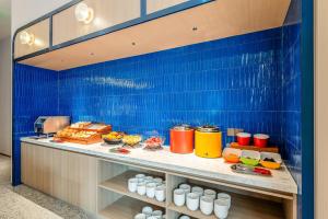 a buffet line with food on a blue tiled wall at Holiday Inn Express Shanghai Changyang Road by IHG in Shanghai