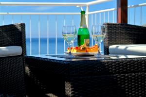 a table with two glasses and a bottle of wine at Komiza Provita Guesthouse in Komiža