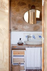 une salle de bain avec un lavabo et un miroir dans l'établissement Can Sisó, Masia Completa, à Crespiá