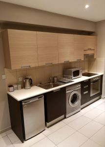 a kitchen with a sink and a washing machine at Beachfront Amazing New Apartment in Limassol