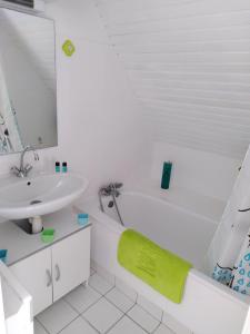 a white bathroom with a tub and a sink at Le studio du dolmen à Plouharnel in Plouharnel