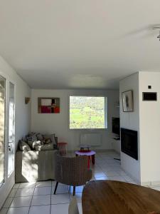 un salon avec un canapé et une table dans l'établissement Chez Mimi - Bellevue, à Raulhac