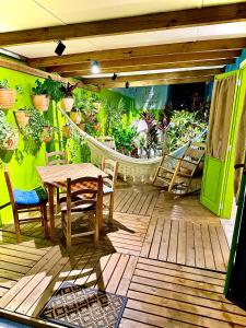 a patio with a table and chairs and plants at Granbalaio Hostel in Blumenau