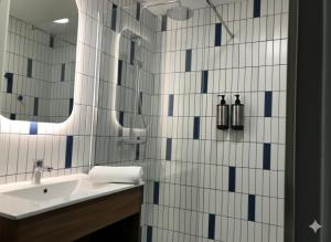 a bathroom with a sink and a mirror at Résidence Harvey Chartres Gare - Cathédrale in Chartres +8 photos