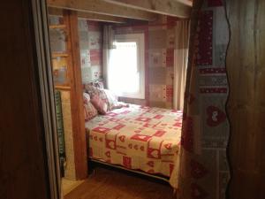 mała sypialnia z łóżkiem i oknem w obiekcie chalet des petits loups w Chamonix-Mont-Blanc
