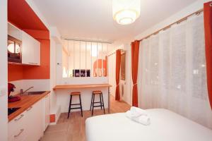 a room with a bed and a kitchen with a counter at Suite romantique avec Spa in Le Mans