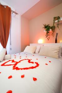 a bed with red rose petals on it at Suite romantique avec Spa in La Celle-sous-Gouzon