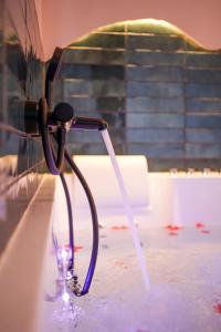 a wine glass sitting in water with a hose at Suite romantique avec Spa in La Celle-sous-Gouzon