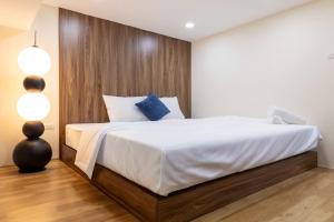a bedroom with a large bed with white sheets and blue pillows at Dfour Home Ngõ Gạch - Old Quarter in Hanoi +7 photos
