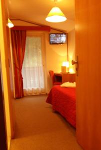 a bedroom with a red bed and a window at Hotel Cristallo in San Martino di Castrozza