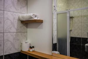 a bathroom with a shower and a sink and a mirror at Özden Pansiyon in Burhaniye