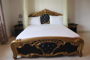 a bedroom with a king sized bed with a wooden frame at Océan Voyages Mitsamihouli in Mitsamiouli +27 photos