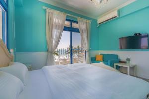 Un dormitorio con una cama blanca y un balcón. en White Sand Homestay, en Hualien City