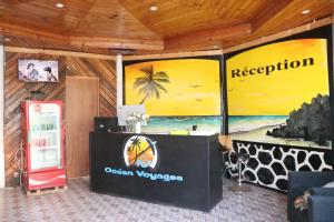 a room with a reception desk with a painting on the wall at Océan Voyages Mitsamihouli in Mitsamiouli