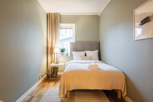 a small bedroom with a bed and a window at Guestly Homes - Spacious 2BR Executive Residence in Luleå