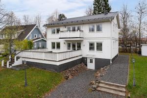 a white house with a porch and a yard at Guestly Homes - Spacious 2BR Executive Residence in Luleå