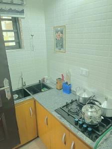 Una cocina con una estufa con ollas y sartenes encima. en LuxeHaven Apartment, en Loburo