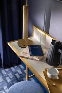 a table with a lamp and a book on it at Hôtel Filigrane & Spa in Paris